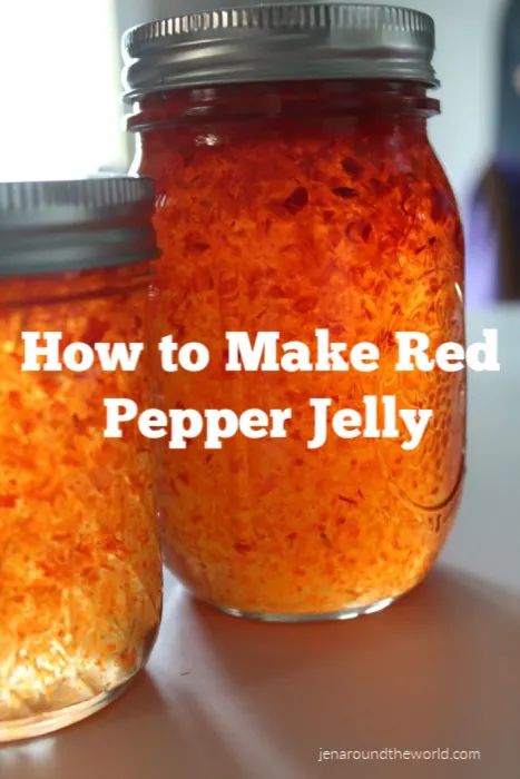 two jars filled with red pepper jelly sitting on top of a table