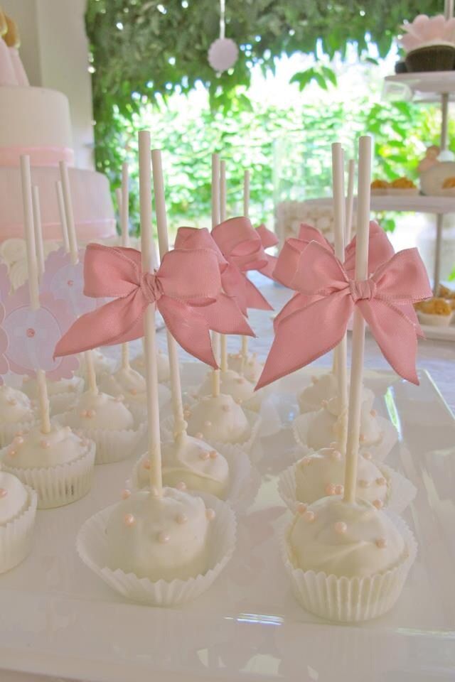 some cupcakes with pink bows are on a table