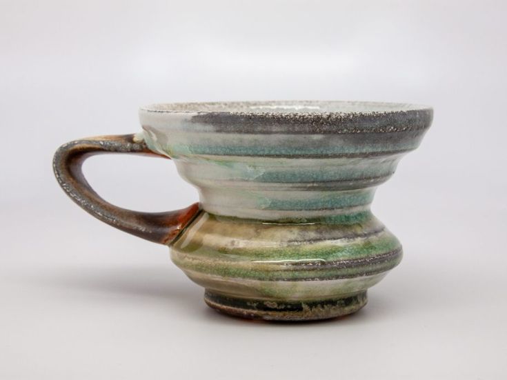 a green and white coffee cup sitting on top of a table