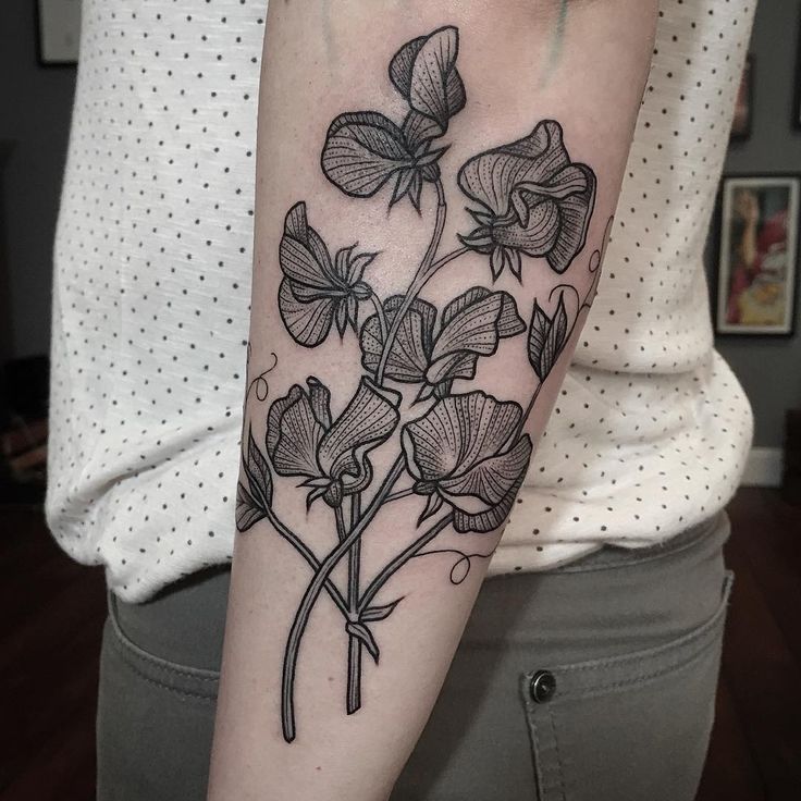 a black and white flower tattoo on the arm