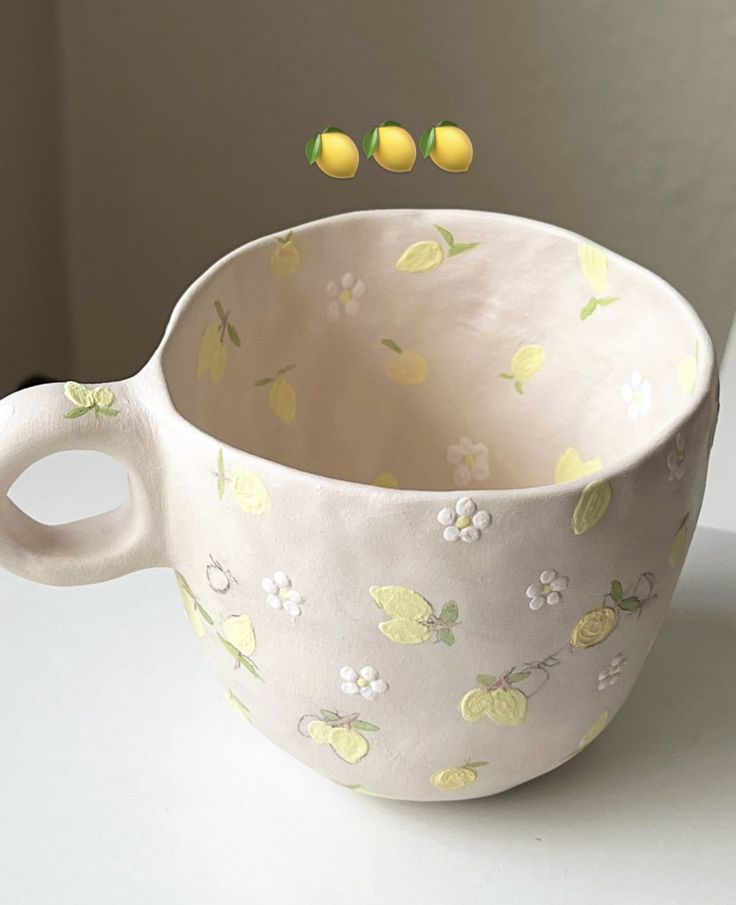 a white cup with lemons and flowers on it