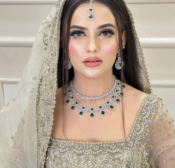 a woman wearing a bridal outfit and jewelry