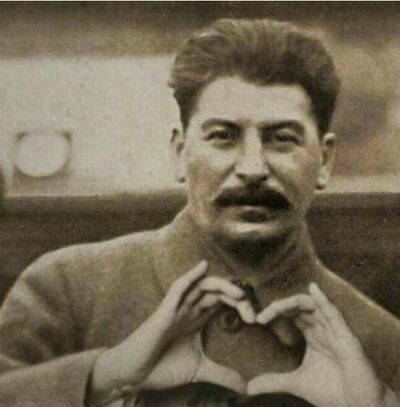 an old black and white photo of a man making a heart with his hands