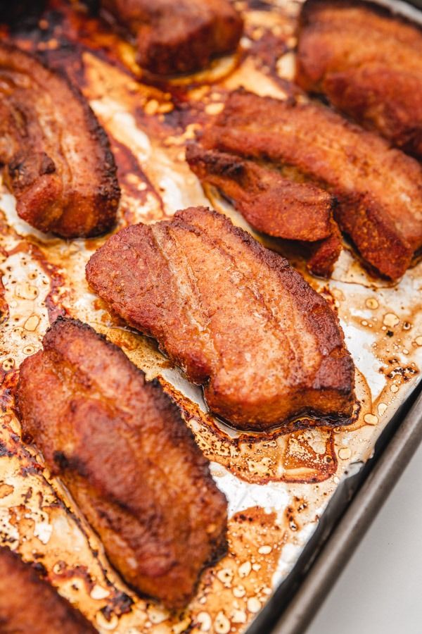 some meat is sitting on a baking sheet