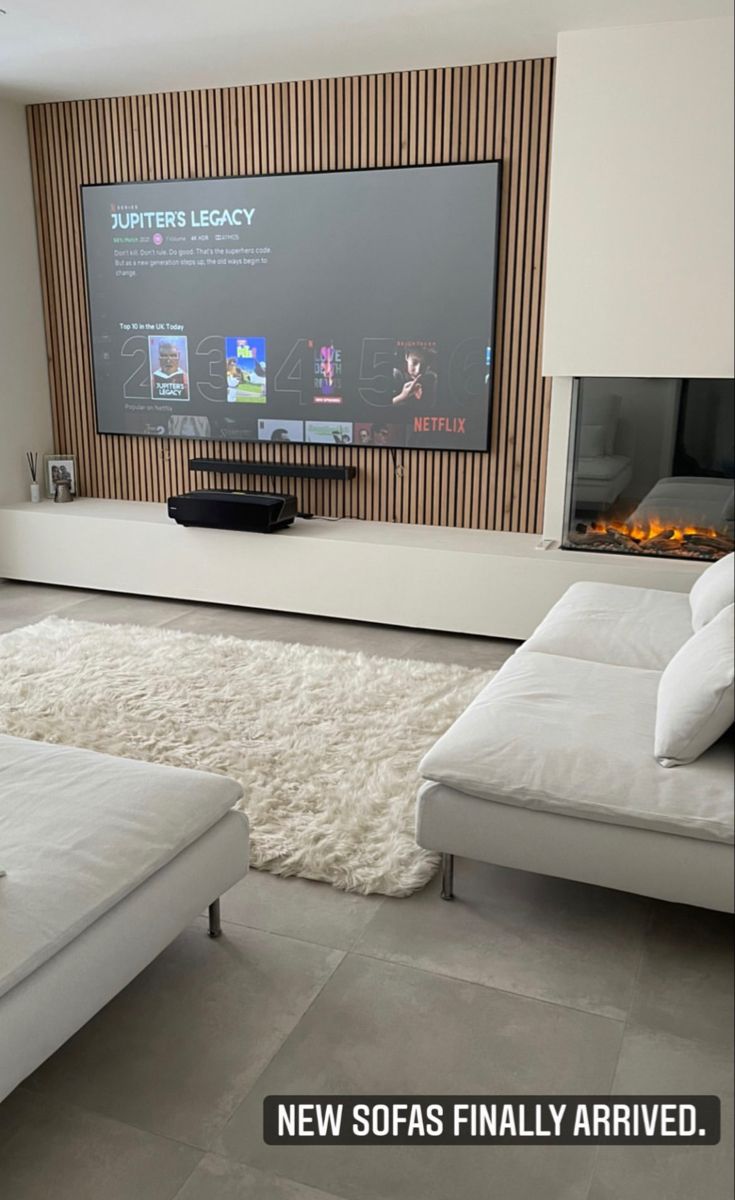 a large flat screen tv mounted to the side of a wall in a living room