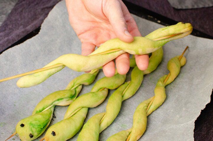 a hand reaching for pea pods on top of a piece of paper