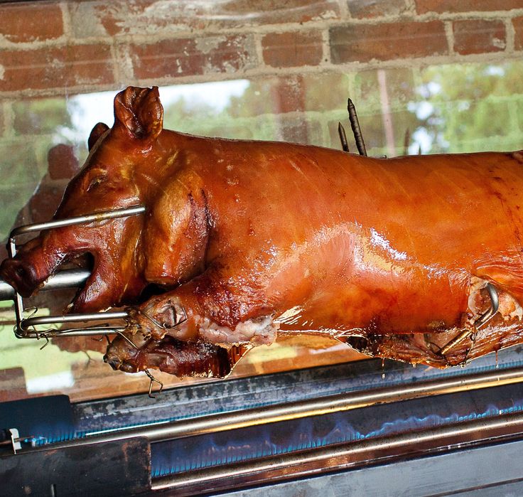 a large piece of meat sitting on top of a grill in front of a brick wall