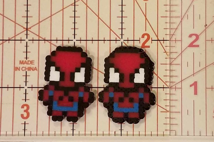 two red and blue pixeles sitting on top of a ruler