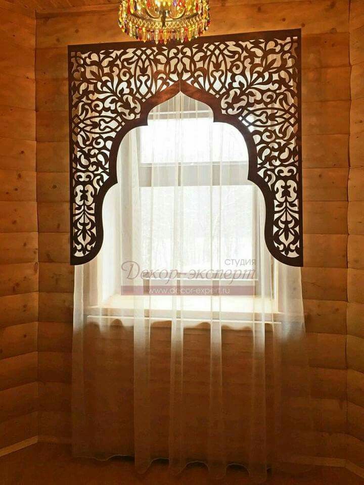 an ornate window with sheer curtains and a chandelier