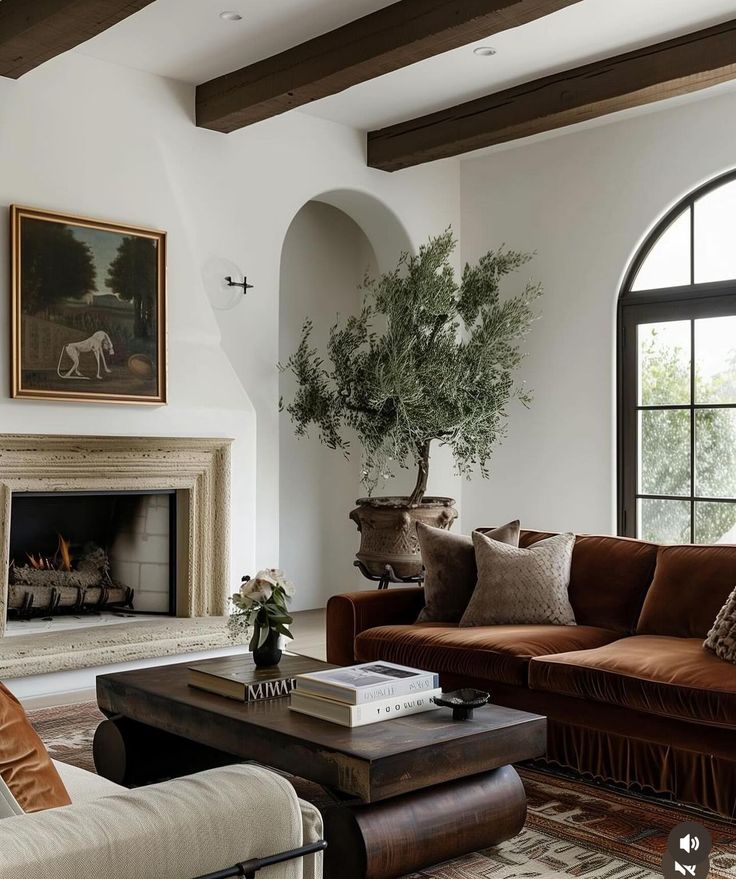 a living room filled with furniture and a fire place in front of a large window