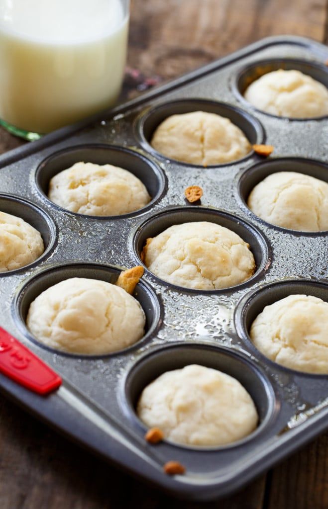 a muffin tin filled with cupcake batters next to a glass of milk