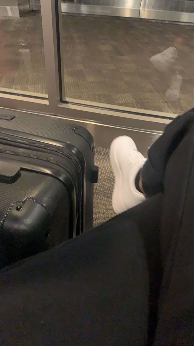 a person with their feet on the ground next to luggage