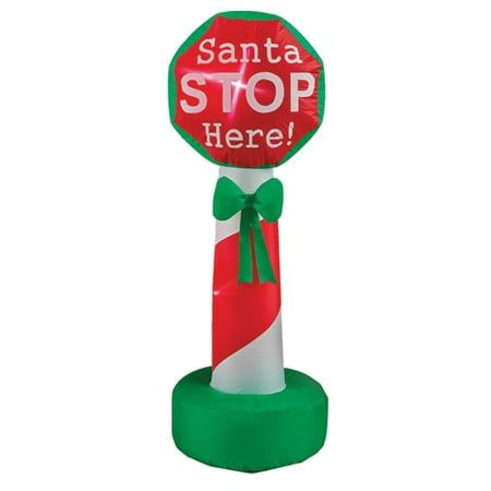 an inflatable santa stop sign with a green bow around it's neck