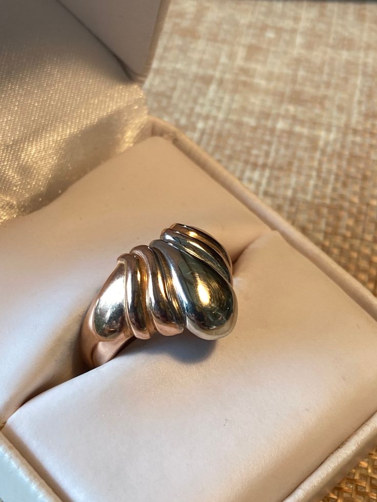 a silver ring sitting in a box on top of a table