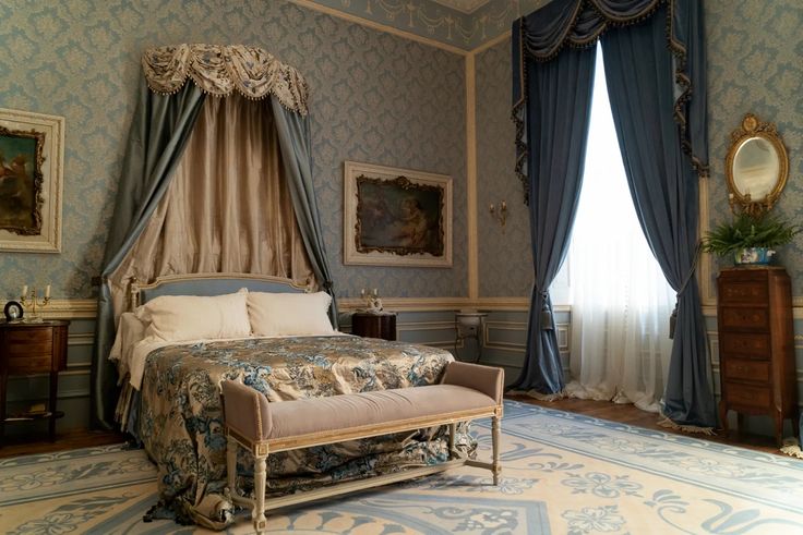 an ornate bedroom with blue walls and curtains