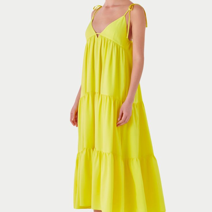 Capture the vibrancy of summer with the Nicola Maxi Dress, a radiant addition to your wardrobe. This sleeveless, floor-grazing dress is a celebration of sunny days with its eye-catching hue and elegant V-neck design. The functional spaghetti bow tie adds a playful yet sophisticated touch, allowing for a personalized fit. The side zipper and back elastic band ensure ease of wear and comfort, while the full lining provides a smooth silhouette. Yellow Maxi Dress, Tie Maxi Dress, Mini Velvet Dress, Yellow Dress, Stand Out From The Crowd, Lightweight Fabric, Neck Designs, Elastic Band, Set Dress