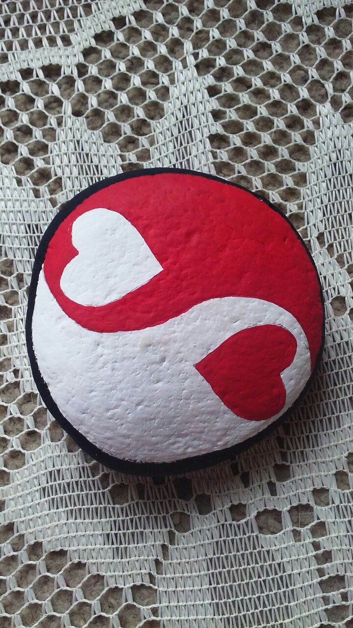 a red and white rock sitting on top of a lace covered surface