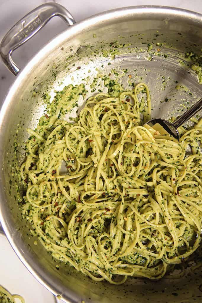 a pan filled with pasta and pesto sauce