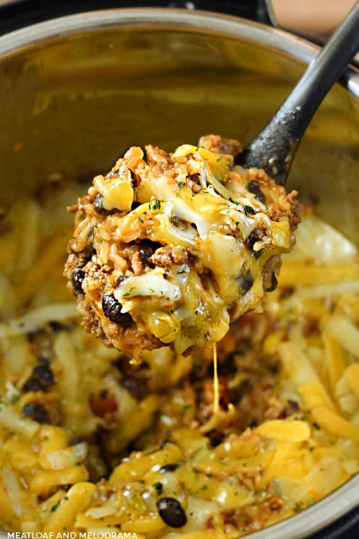 a ladle full of pasta and cheese being lifted from the crock pot