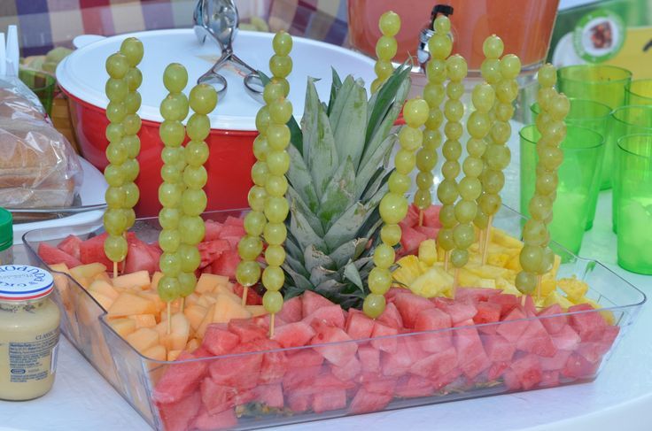 there are many different fruits and vegetables in the trays on the table, including pineapple