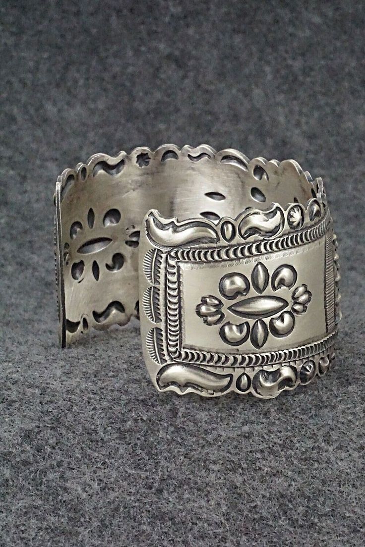 This stunning and intricate sterling silver bracelet was made by Navajo silversmith Eugene Charley. The inside is signed and stamped sterling.Size: 6" (will fit up to a 7 3/8" wrist)Gap: 1 3/8"Width: 1 1/2"Free shipping on all orders! We ship with USPS and always include tracking. All orders ship within a day of payment.Returns are accepted up to 30 days after you receive your order. Just send us a message. Our shop offers cash back or store credit. The item must be returned in new condition. Ornate Antique Silver Sterling Bracelets, Antique Silver Sterling Silver Bracelet With Intricate Design, Antique Silver Sterling Silver Bracelets With Intricate Design, Ornate Sterling Silver Bangle Jewelry, Adjustable Ornate Sterling Silver Bracelet, Adjustable Antique Silver Jewelry With Intricate Design, Ornate Sterling Silver Engraved Bracelet, Collectible Etched Antique Silver Jewelry, Southwestern Engraved Sterling Silver Bracelet Gift