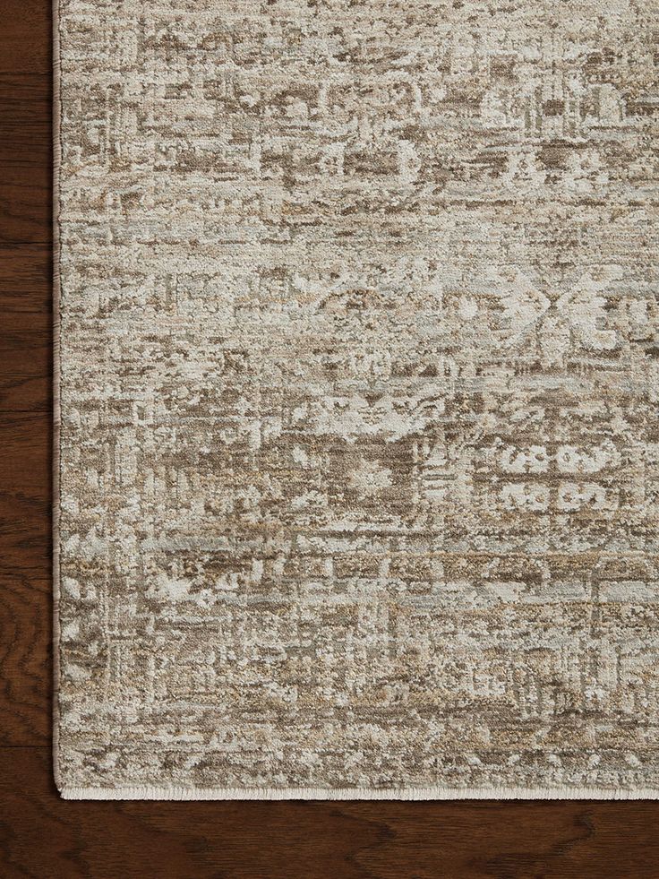 an area rug with brown and white colors on top of a wooden flooring surface