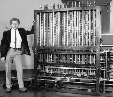 a man standing in front of a large machine with lots of wires attached to it