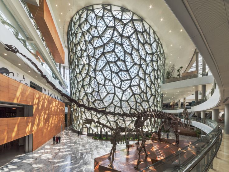 the inside of a large building with lots of glass and wood on it's walls