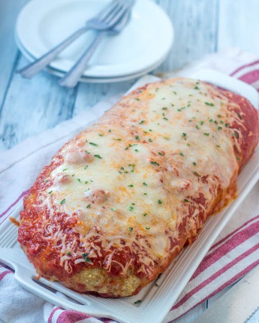 a cheesy lasagna on a plate with a fork next to it