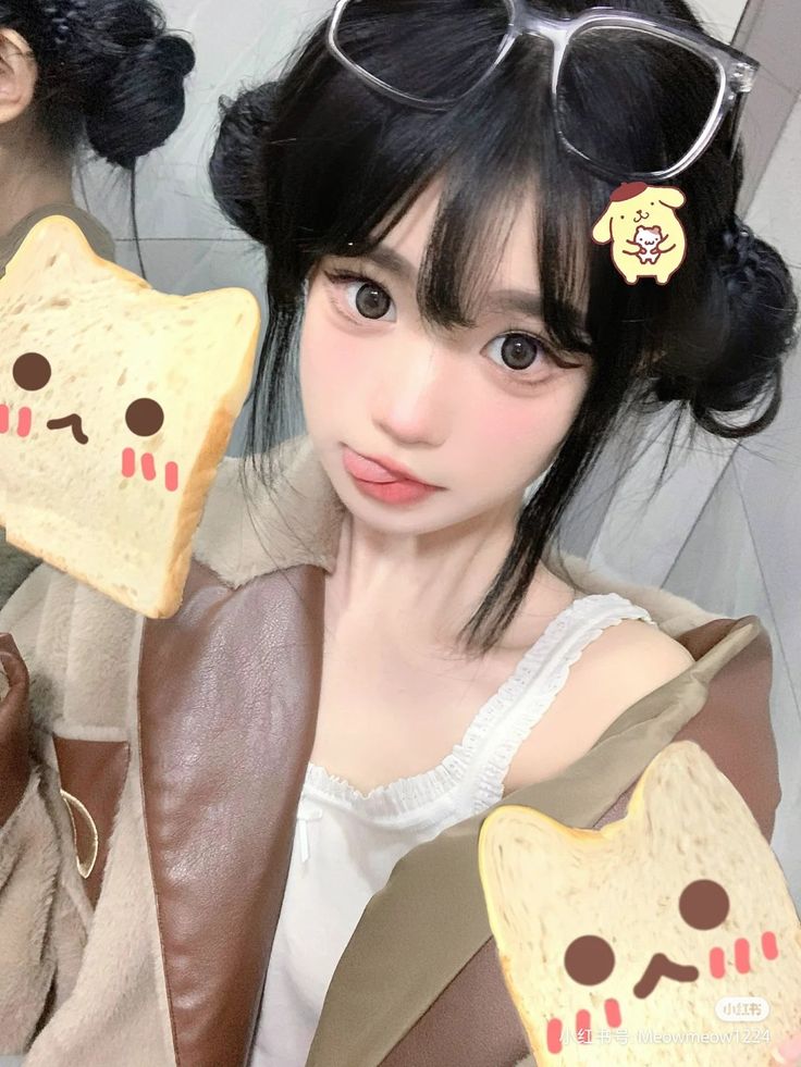 a girl with glasses holding up slices of bread