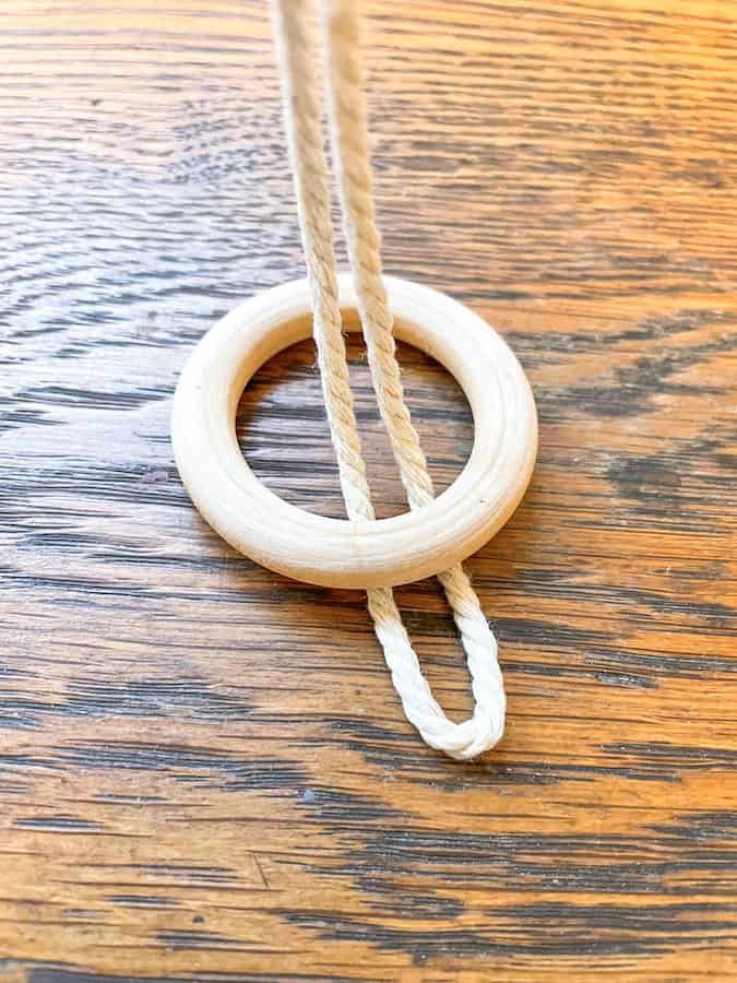 a close up of a wooden ring on a table with ropes hanging from it's sides