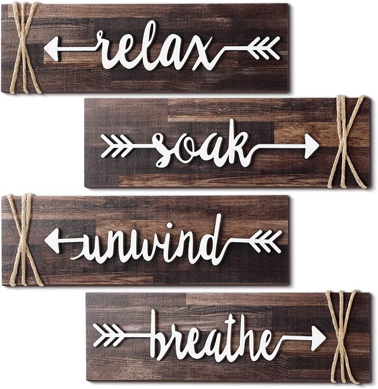 three wooden signs that say relax, soak, wind and breathe with arrows on them