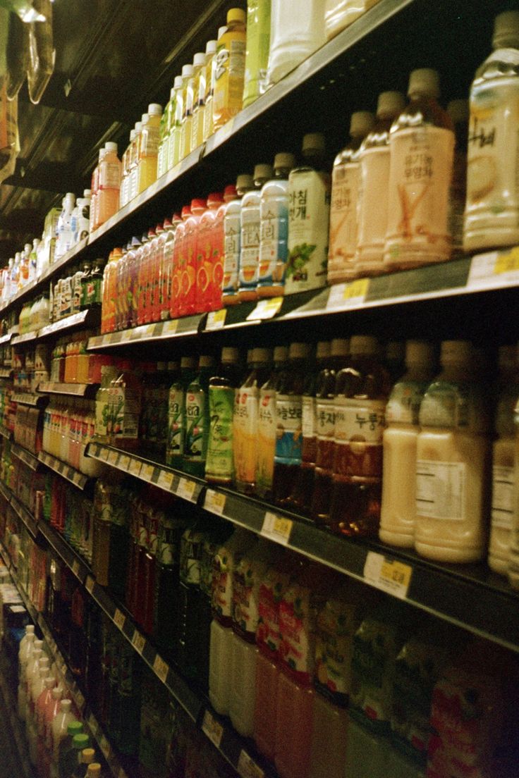 a store filled with lots of different types of drinks and juices on the shelves