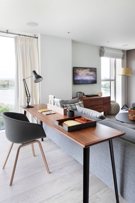 a living room filled with furniture and a wooden table in front of a large window