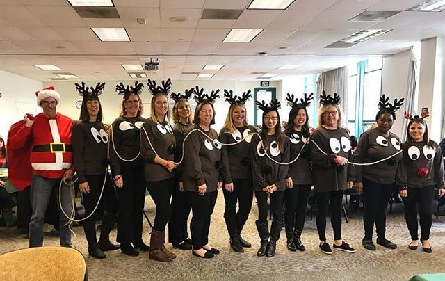 a group of people standing next to each other wearing reindeer costumes