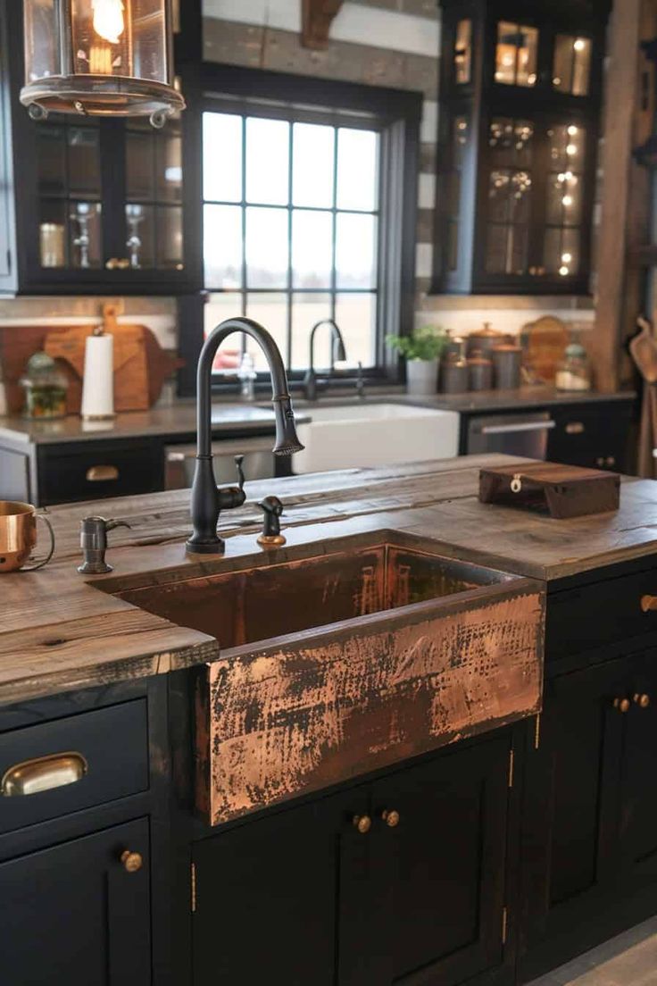 a kitchen with black cabinets and an copper sink in the center is surrounded by wood counter tops