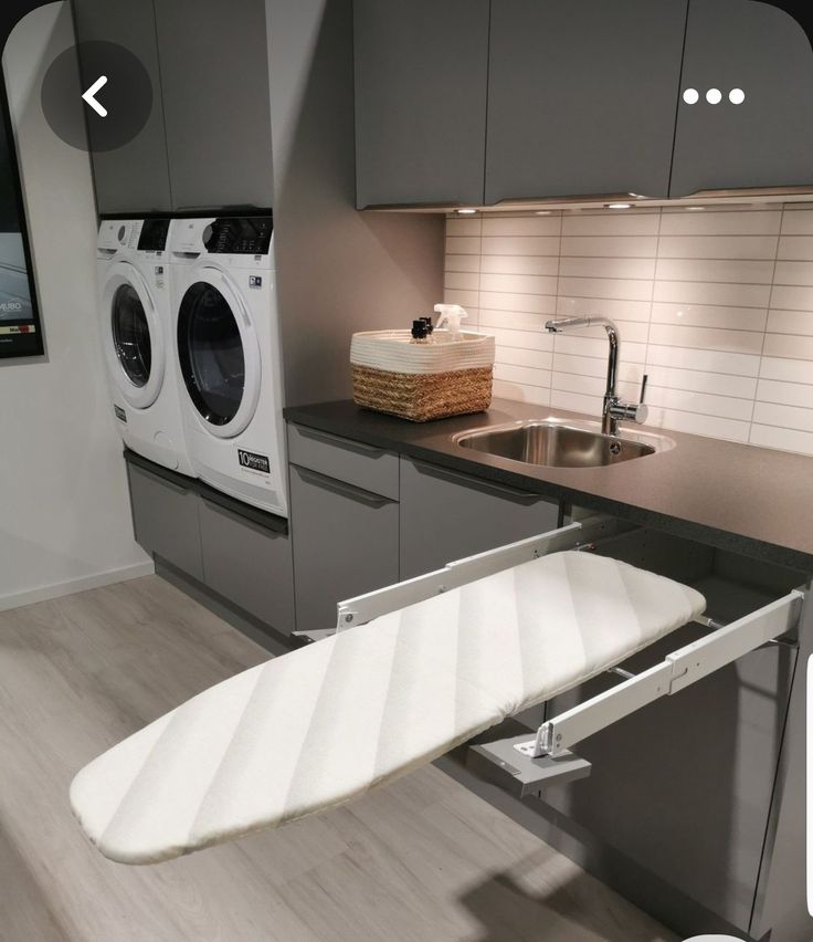 a white surfboard sitting on top of a kitchen counter next to a washer and dryer