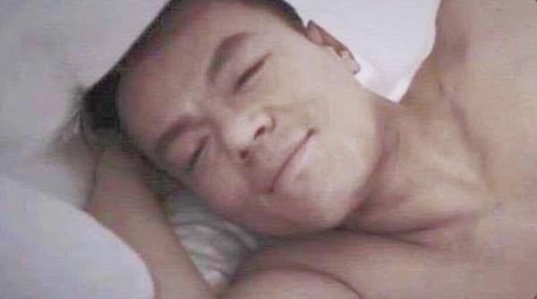 a man laying in bed with his eyes closed