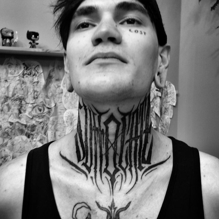 a man with tattoos on his neck and chest