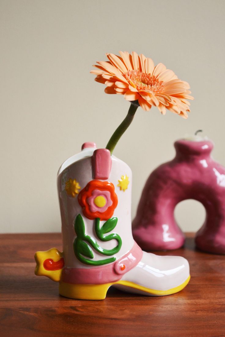 a flower in a cowboy boot and another vase