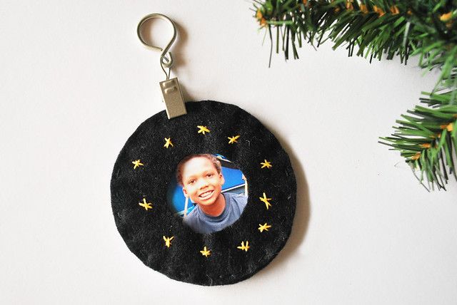 a black ornament with a photo of a man on it hanging from a christmas tree