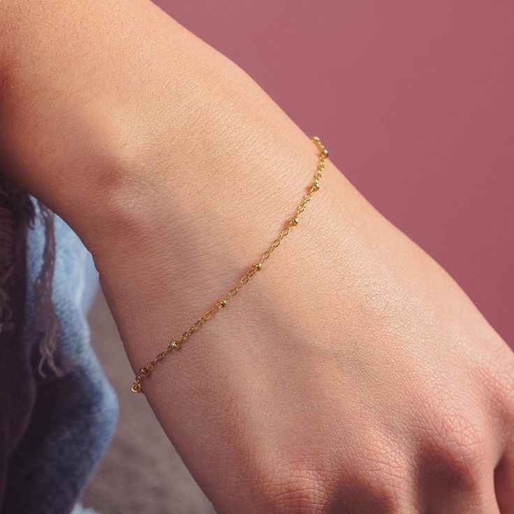 The Satellite Chain Bracelet is a chic and stylish chain, the perfect accessory to take your look to the next level. Crafted with gold or silver dotted bead chain, this dainty gold chain is perfect for easy layering and creates a simple and elegant statement. Rich gold or silver dots complement the design, giving the bracelet added character. Gold Ball Chain Bracelet Gift, Minimalist Beaded Bracelets With Ball Chain, Yellow Gold Ball Chain Bracelet, Elegant Adjustable Ball Chain Bracelet, Elegant Ball Chain Bracelet As Gift, Elegant Ball Chain Bracelet Gift, Adjustable Gold Bracelet With Satellite Chain, Adjustable Bracelet With Satellite Chain And Round Beads, Dainty Chain Bracelet With Adjustable Round Beads