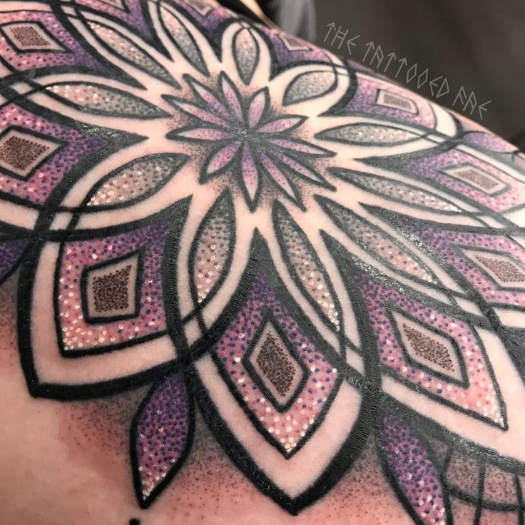 the back of a woman's shoulder with an intricate design on it