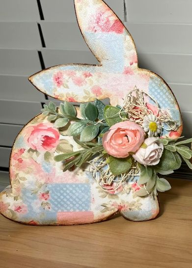 a wooden bunny with flowers and leaves on it