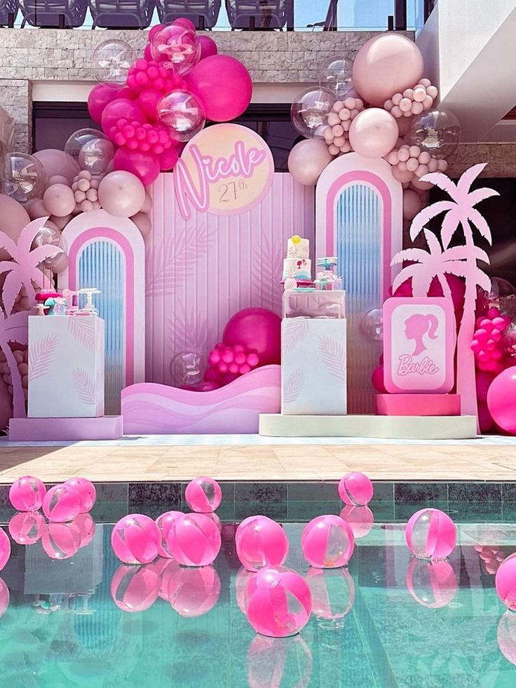 an outdoor pool decorated with pink balloons and decorations