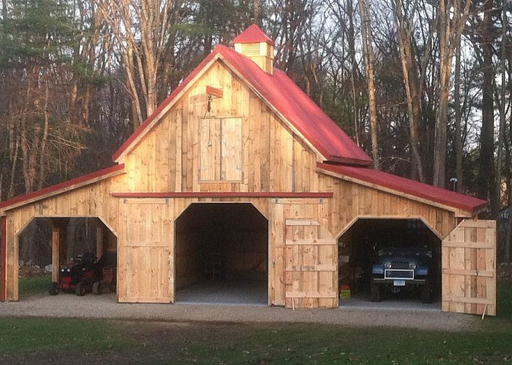 a large wooden building with two doors and a red roof