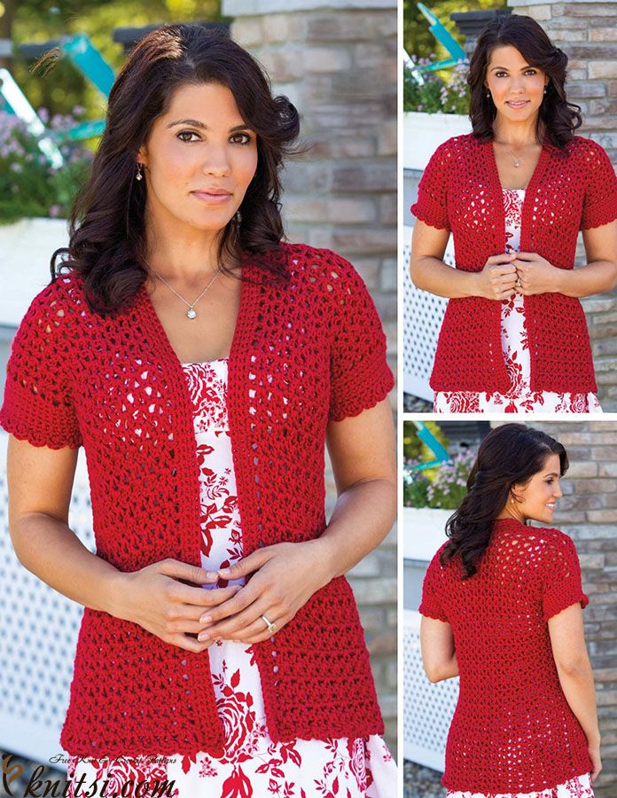 a woman wearing a red crochet cardigan standing in front of a brick wall