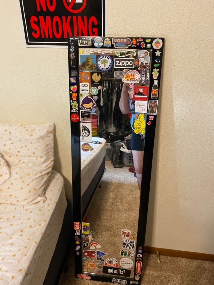 there is a mirror that has stickers on it in the corner next to a bed