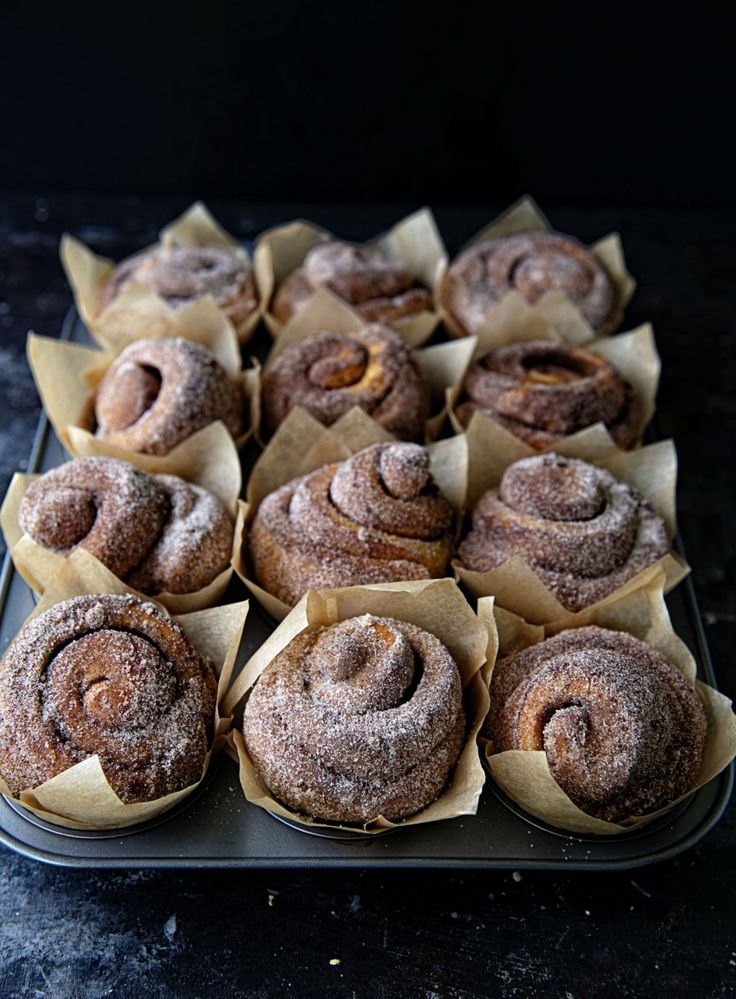 there are many cinnamon rolls on the tray