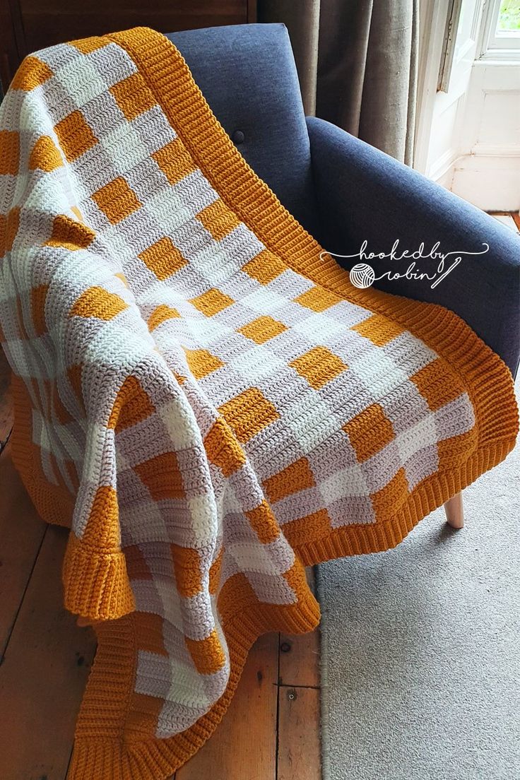 an orange and white blanket sitting on top of a blue chair